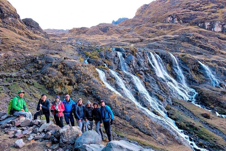 Trekkers beside a waterfall in the Lares Valley