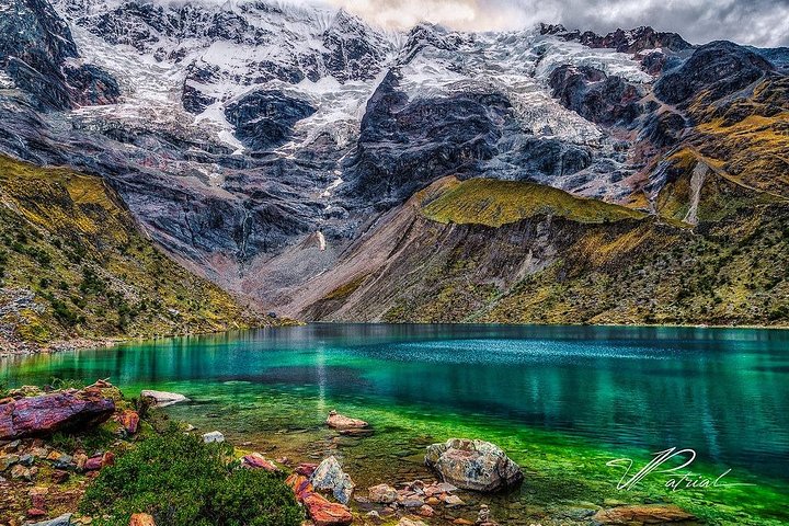Hikers beside Humantay Lake below Salkantay