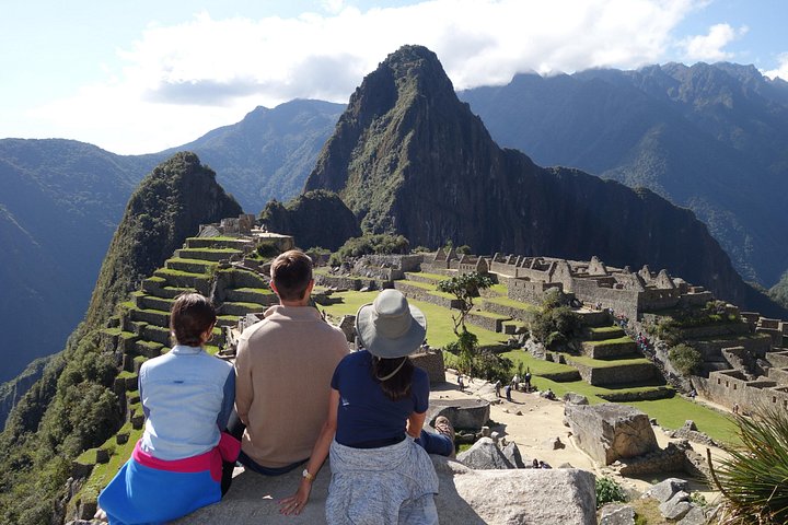 Two visitors seated above Machu Picchu