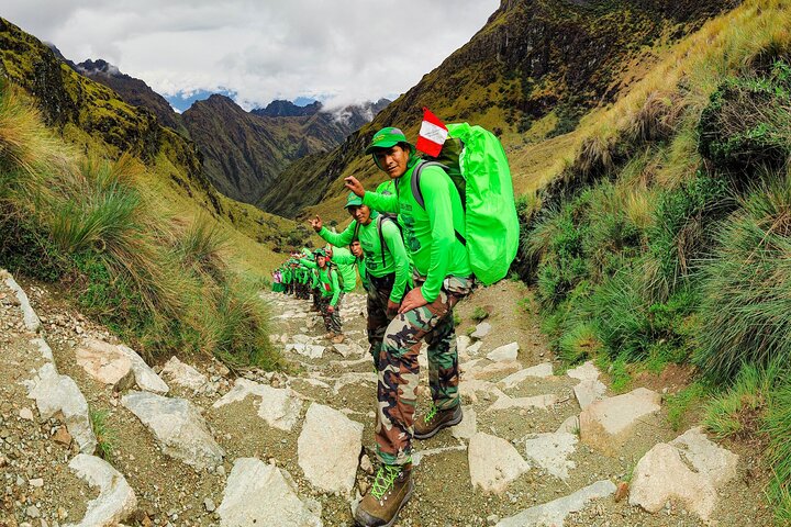 Trekkers with packs on a stone trail in the Andes