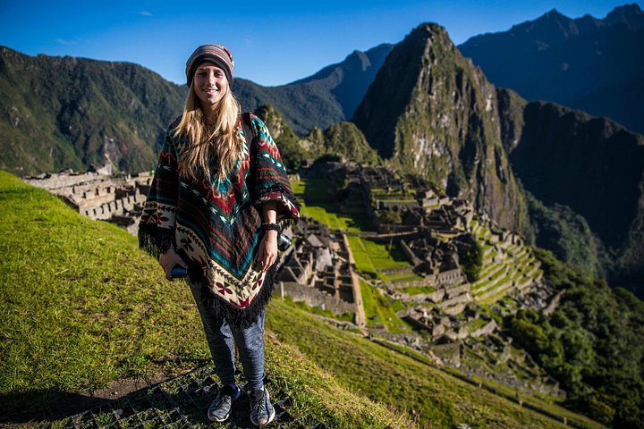 A visitor in a poncho on the Machu Picchu terraces