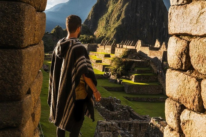 A man in a poncho at an Inca doorway